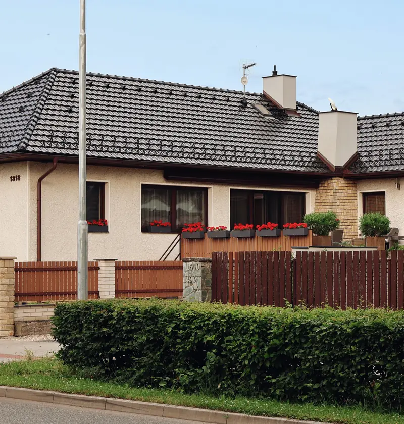 Parterowy dom jednorodzinny z ogrodzeniem i żywopłotem